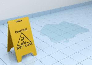 Photo of wet floor sign next to a water spill